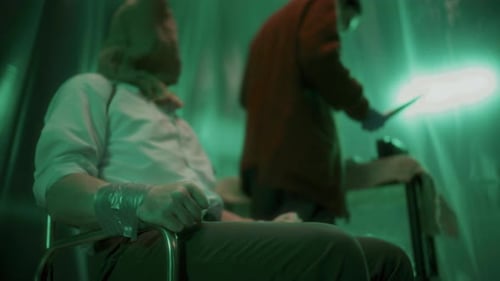 Une victime impuissante attachée à une chaise avec un sac sur la tête tente d'échapper à Maniac