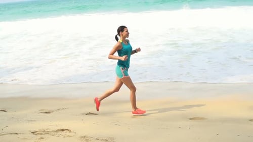 Woman Jogging On Beach Near Sea