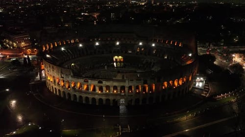 Aerial fly drone view of Colosseum or Coliseum at night, Rome, Italy, Europe. Ancient Roman ruin is