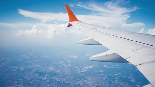 Asa de sobrevoar o oceano e a ilha de avião da janela sobre nuvens em céu azul nublado Asa de aeronave