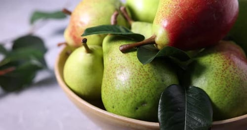 Fresh ripe pears and green leaves on table, closeup
