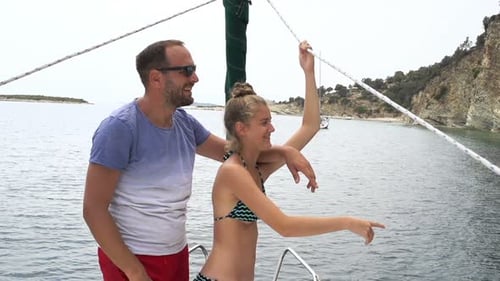Father and daughter enjoying exotic sailing boat trip on the sea in super slow motion