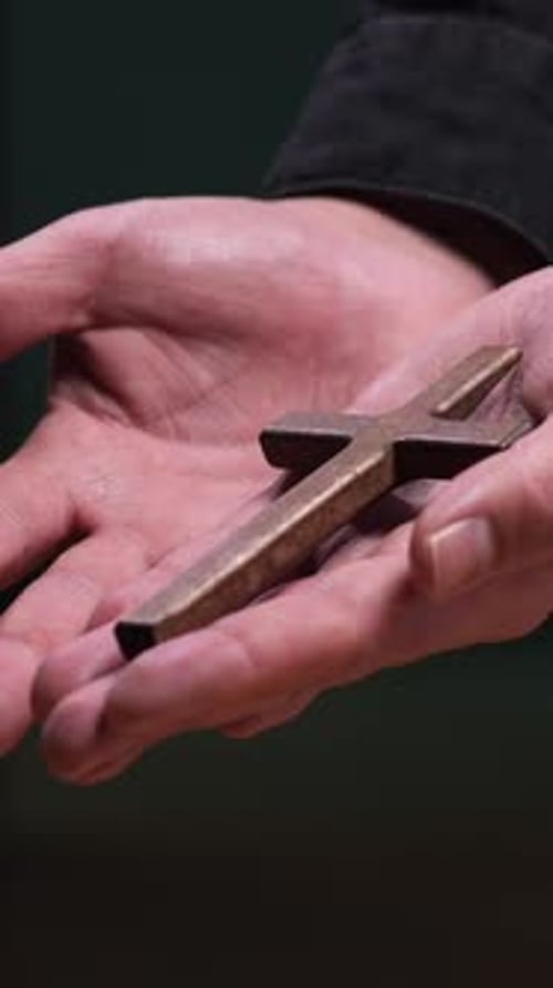 Hands Holding a Bronze Cross