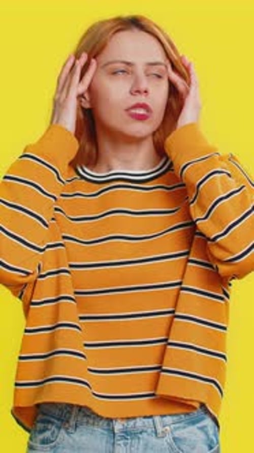 Woman Experiencing Headache With Yellow Background
