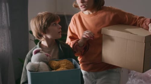 Boy Carrying Boxes with his Toys, Helping Parents Relocate Into New apartment