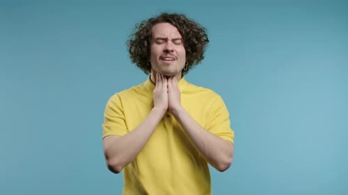 Ill Handsome Man Has Sore Guy with Swollen Throat on Blue Studio Angina Pain