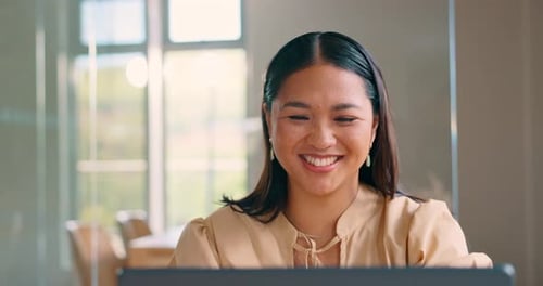 Woman Smiling While Working on Laptop