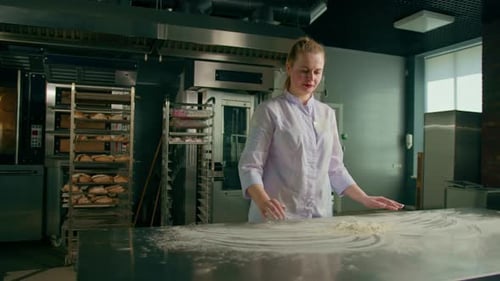 professional chef throws flour on table stirs it before preparing bread pastry in bakery