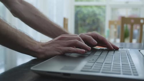 Working from home using a laptop track pad mouse on kitchen counter side angle