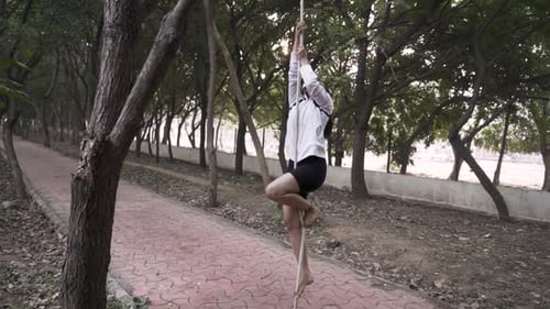 A sporty gymnast performs exercises with a rope in sportswear.Concept: power, strength, healthy life