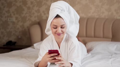Woman Relaxing in Hotel Room Using Smartphone