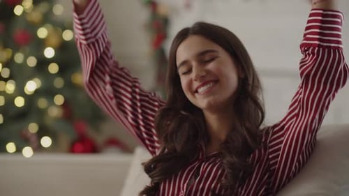 Woman Laughing near Christmas Tree in Home