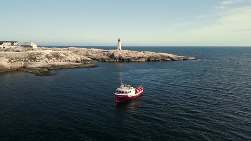 Aerial View Professional Lobster Boat in Peggy's Cove with a Lighthouse on Shore