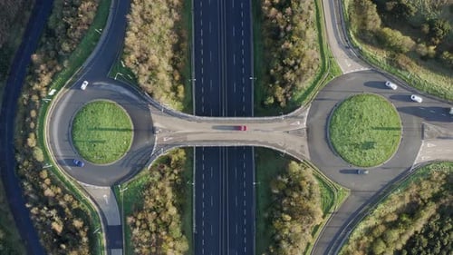 Vertical aerial timelapse of highway roundabouts and motorway traffic