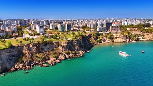 Beautiful rocky shore of Antalya, Turkey. Some boats are on the water.