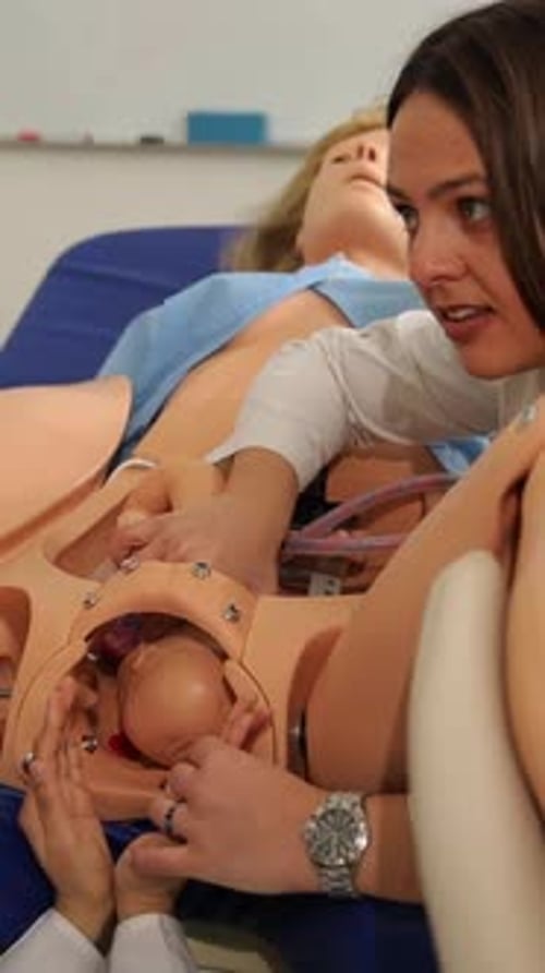 Woman Demonstrates Childbirth Using Birthing Model