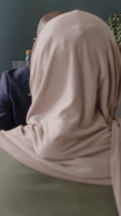 Vertical of Black Male Visa Officer Interviewing Muslim Woman in US Embassy