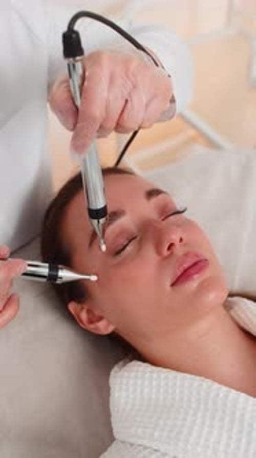 Young Woman Receives Microcurrent Therapy for Eyes Area at Beauty Clinic Rejuvenation Session