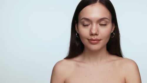 BareShouldered Woman Looking to the Side on Blue Background