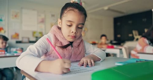Child Writing at Desk in Bright Classroom