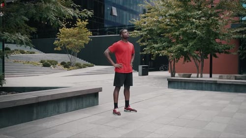 Sportive Man Preparing for Training By Stretching on Street