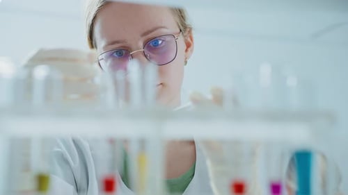Scientist Analyzing Colorful Liquid in Test Tubes