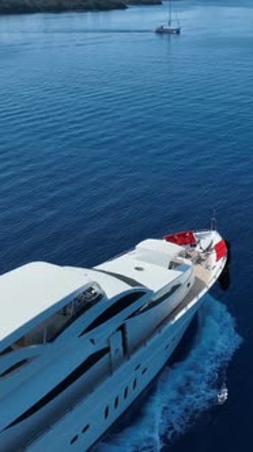 Aerial view of a luxurious white yacht cruising on deep blue ocean waters