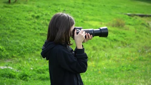 Child Photographer with Camera in Green Field