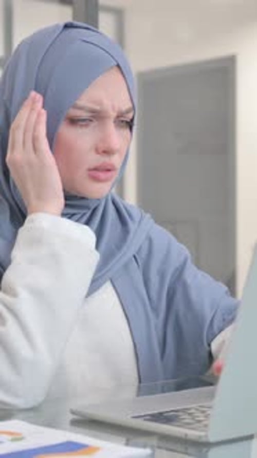 Woman Works at Laptop in Office with Headache