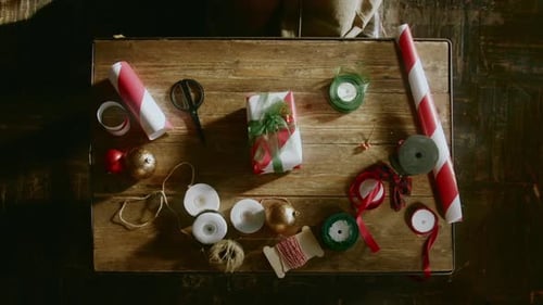 Hands Placing Christmas Gift on Table