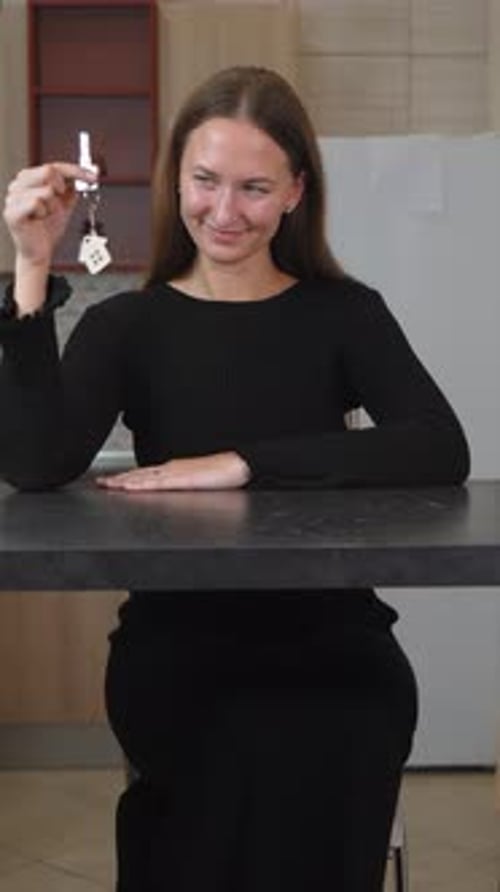 Woman holding keys to key fob from house