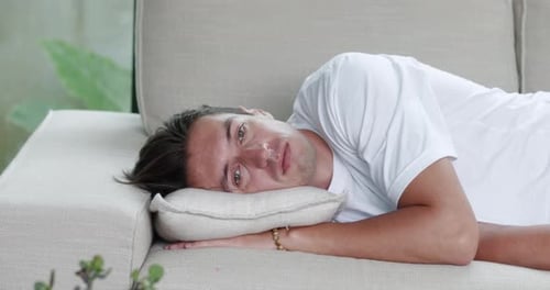 Sad Man Lies on Couch and Suffers From Depression at Home