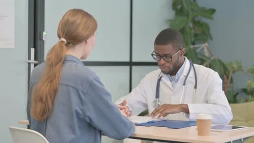 African Doctor Talking with Patient in Clinic