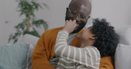 Loving Father and Son Embrace on Couch