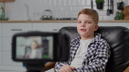 Boy Records Video Blog On Camera Young Blogger Talking to Camera on Tripod Close Up