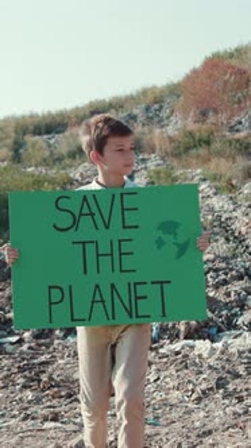 A Young Activist Passionately Holding a Sign That Promotes Awareness for the Environment