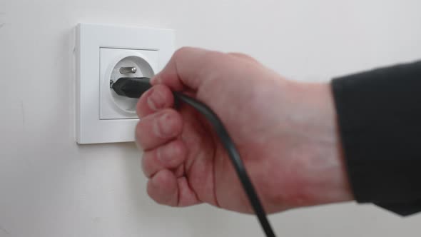 Male Hand Plugging and Unplugging Plug Into White Wall Socket ...