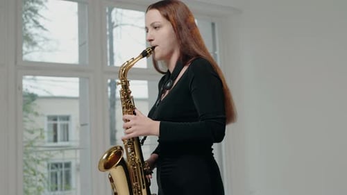 Woman Plays Saxophone in Brightly Lit Room