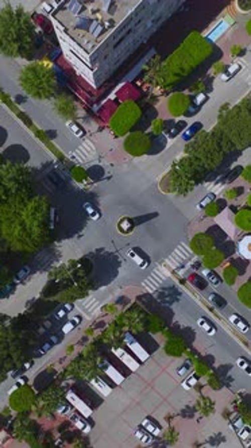 Vertical Video Aerial Footage of a Cityscape with Busy Crossroads Vehicles in Motion and the Rhythm
