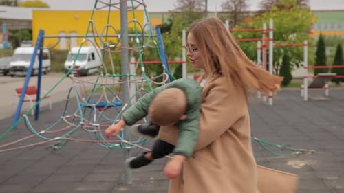 Une jeune mère tenant son petit enfant dans ses bras se baladant avec lui