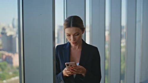 Stylish Businesswoman Messaging Mobile Phone Online in Modern Office Closeup