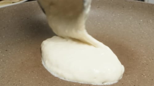 I pour the pancake batter into the pan. extreme close-up.