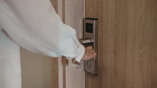 A Woman Opens a Hotel Room Using a Card Key Magnetic Lock in the Hotel Room Door