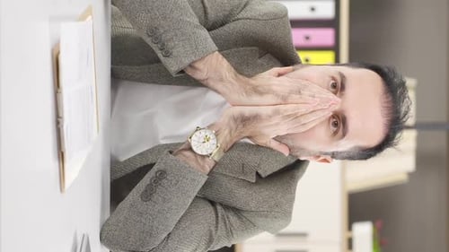 Frustrated Man Sitting at Desk in Office
