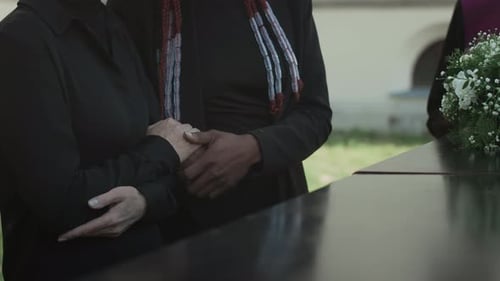 Mourners Standing by Casket during Funeral Service