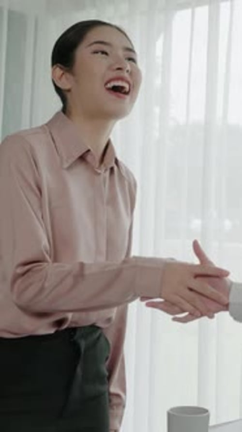 Woman smiling and shaking hands in office setting