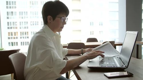 Attractive Mature Businesswoman Working on Laptop in Office or Coworking