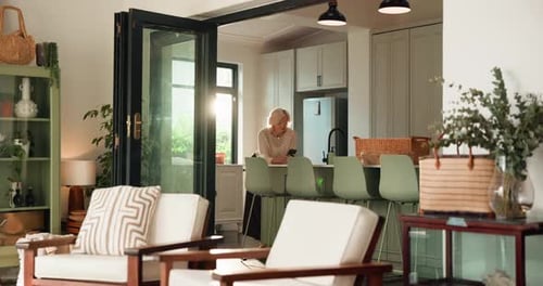 Phone, retirement and text message with old woman in kitchen of home for browsing or scrolling