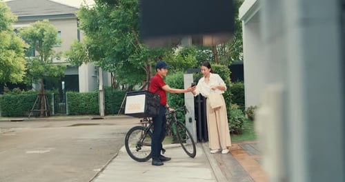 man shopping paper bag to woman in front of door lady scan QR code payment on smartphone.