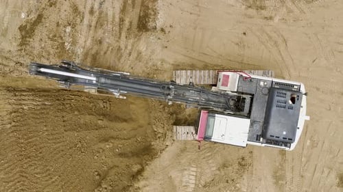 Die Erdarbeiten beginnen mit der Luftaufnahme von Baggern und Lastwagen auf der Baustelle